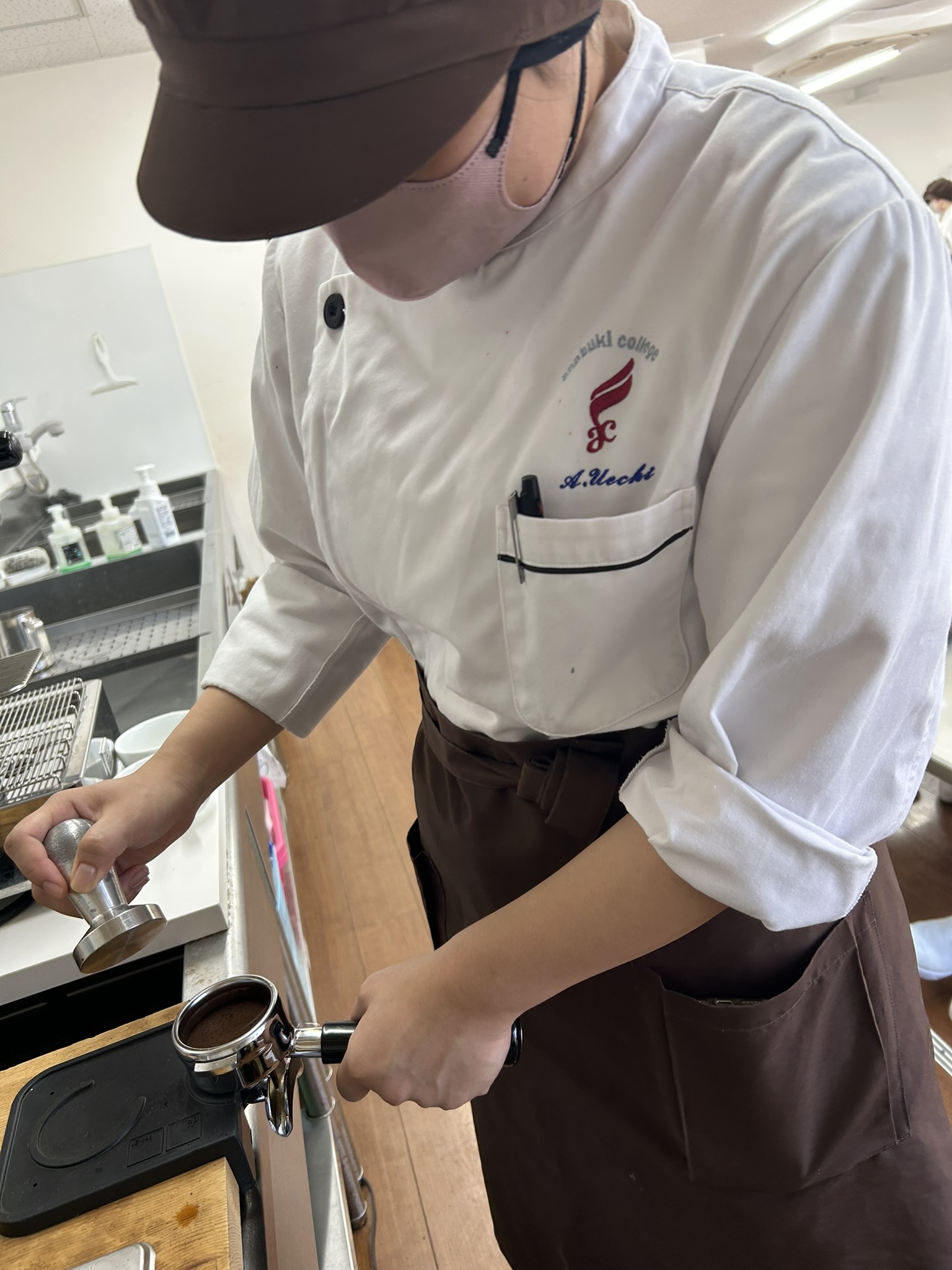 挽いたコーヒー豆をポルタフィルターに詰める作業